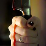 A hand holding a bloody knife.