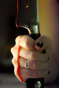 A hand holding a bloody knife.