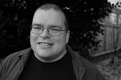 Headshot of Harry Connolly wearing a black t-shirt.